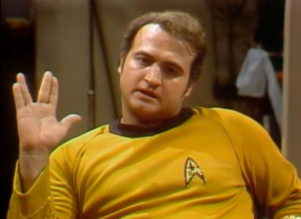 Actor John Belushi, dressed as Captain Kirk, giving the Vulcan salute